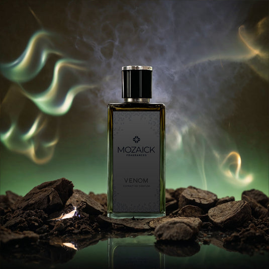 VENOM Extrait de Parfum 50 ml von MOZAICK – Flakon zwischen dunklen Holzstücken mit Rauch vor grünem Grund